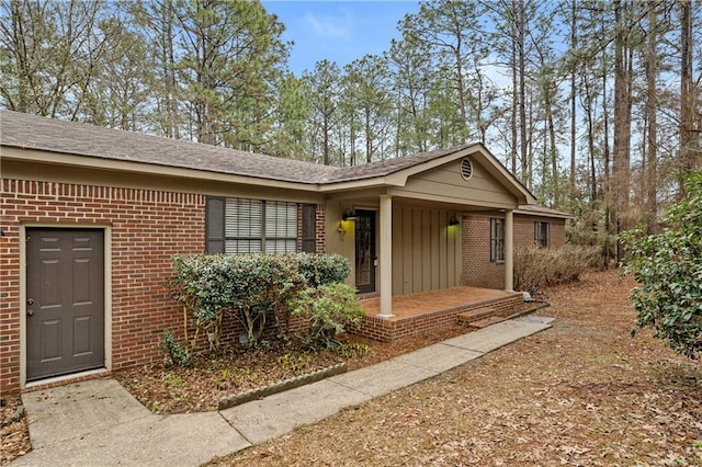 ranch-style house with covered porch, board and batten siding, and brick siding