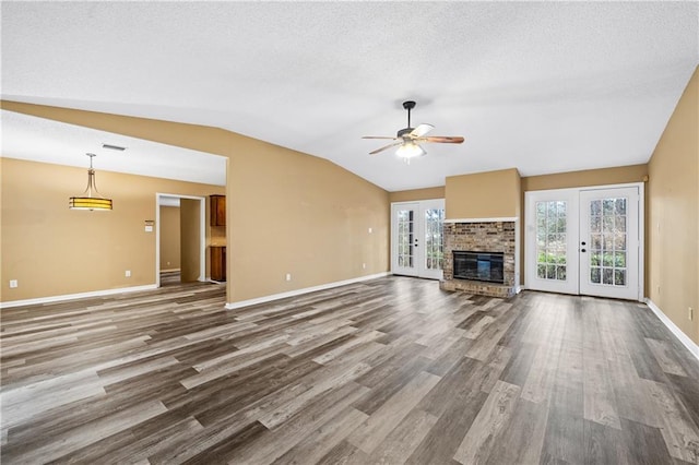 unfurnished living room featuring lofted ceiling, french doors, and wood finished floors