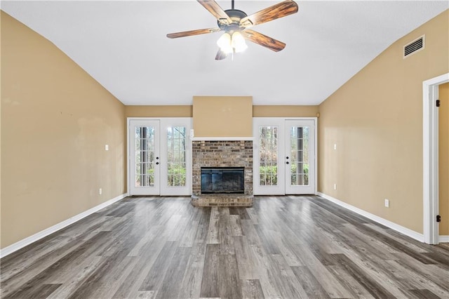 unfurnished living room featuring french doors, plenty of natural light, and a brick fireplace