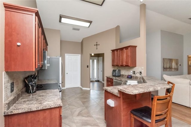 10234 Scott Plantation Dr N, Mobile, AL 36695 - kitchen with vaulted ceiling, tasteful backsplash, a peninsula, open floor plan, and a kitchen bar