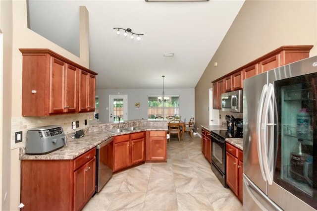 10234 Scott Plantation Dr N, Mobile, AL 36695 - kitchen featuring stainless steel appliances, a peninsula, brown cabinetry, backsplash, and hanging light fixtures