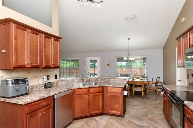 10234 Scott Plantation Dr N, Mobile, AL 36695 - kitchen featuring appliances with stainless steel finishes, lofted ceiling, a peninsula, healthy amount of natural light, and brown cabinets