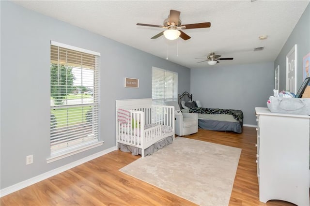 10234 Scott Plantation Dr N, Mobile, AL 36695 - bedroom featuring wood finished floors, a textured ceiling, and a ceiling fan