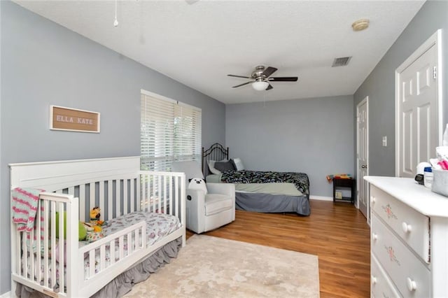 10234 Scott Plantation Dr N, Mobile, AL 36695 - bedroom with wood finished floors, ceiling fan, and a textured ceiling