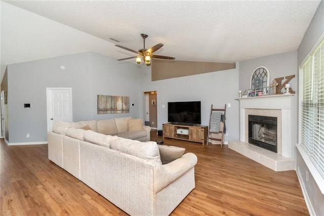 10234 Scott Plantation Dr N, Mobile, AL 36695 - living room featuring a ceiling fan, light wood-style flooring, vaulted ceiling, and a tile fireplace