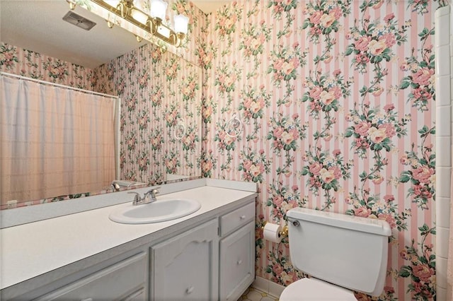 bathroom with vanity, visible vents, wallpapered walls, and toilet