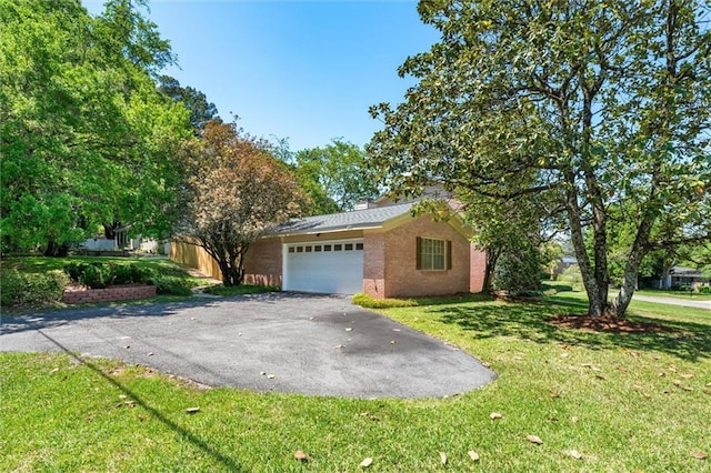 view of front of house featuring driveway, a garage, a front lawn, and brick siding