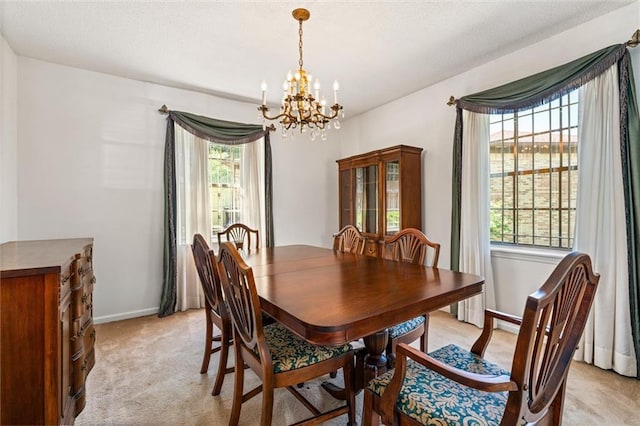 dining room featuring baseboards, light colored carpet, and an inviting chandelier