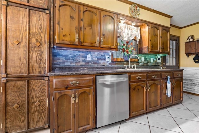 kitchen featuring dark countertops, stainless steel dishwasher, a textured ceiling, and crown molding