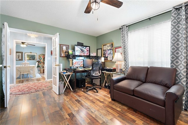 home office with wood finished floors, a ceiling fan, a textured ceiling, and french doors