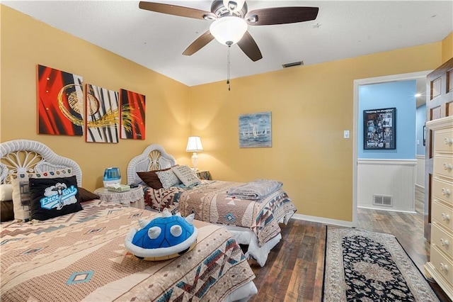 bedroom with wood finished floors, ceiling fan, visible vents, and baseboards