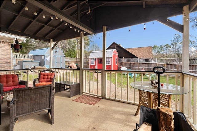 view of patio / terrace featuring a storage unit, outdoor lounge area, an outdoor structure, and a fenced backyard