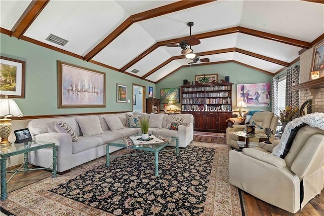 living area with a ceiling fan, visible vents, vaulted ceiling with beams, and wood finished floors