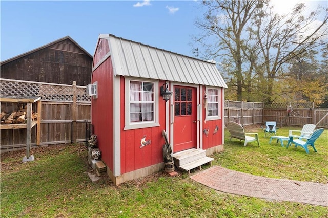 view of shed featuring entry steps and a fenced backyard
