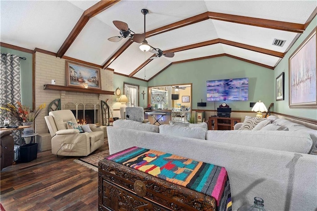 living area featuring lofted ceiling with beams, a fireplace, dark wood-style floors, visible vents, and a ceiling fan