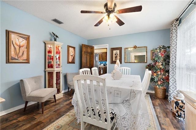 dining area featuring dark wood-style floors, visible vents, ceiling fan, and baseboards