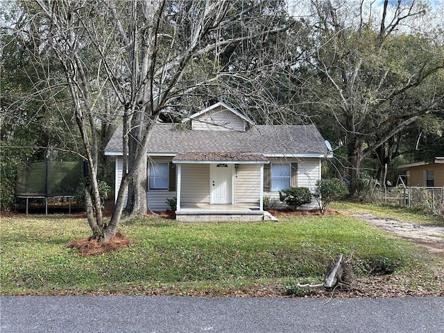 view of front of property featuring a trampoline and a front yard