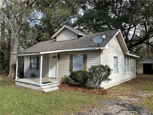 view of front of home featuring a porch, a shed, and a front lawn