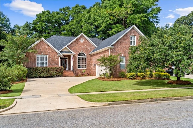 9791 Aspen Cir, Daphne, AL 36527 - view of front of house with brick siding, concrete driveway, a front lawn, and an attached garage