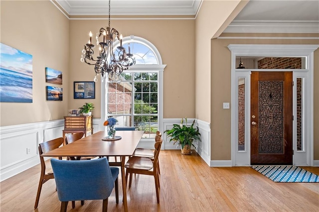 9791 Aspen Cir, Daphne, AL 36527 - dining room featuring a chandelier, ornamental molding, light wood-style floors, a wainscoted wall, and a decorative wall