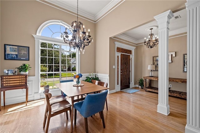 9791 Aspen Cir, Daphne, AL 36527 - dining space featuring a chandelier, crown molding, light wood-style floors, decorative columns, and wainscoting