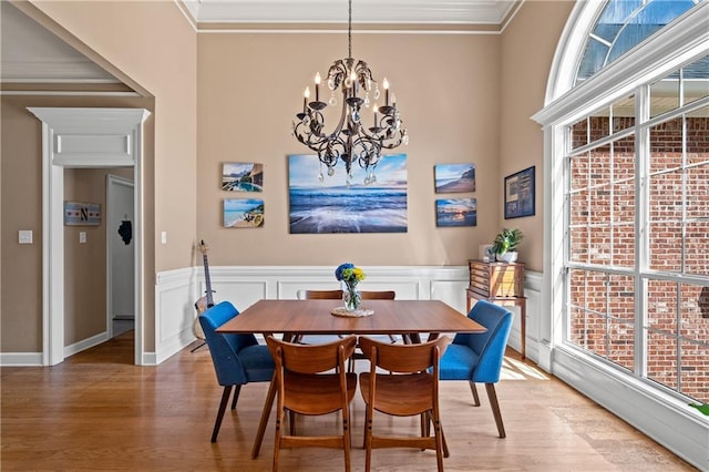 9791 Aspen Cir, Daphne, AL 36527 - dining area with light wood-style flooring, ornamental molding, plenty of natural light, a chandelier, and wainscoting