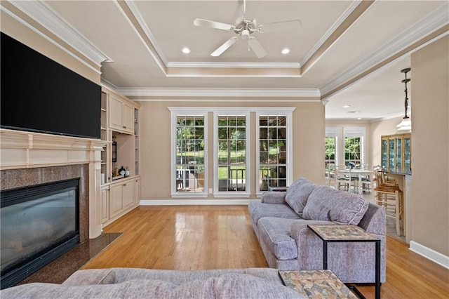 9791 Aspen Cir, Daphne, AL 36527 - living area with light wood-style flooring, ornamental molding, a raised ceiling, ceiling fan, and a premium fireplace
