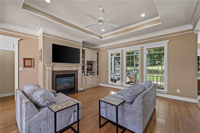 9791 Aspen Cir, Daphne, AL 36527 - living room featuring a raised ceiling, ceiling fan, a high end fireplace, wood finished floors, and ornamental molding