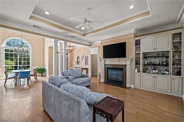 9791 Aspen Cir, Daphne, AL 36527 - living area with a chandelier, a tray ceiling, a premium fireplace, light wood-type flooring, and ornamental molding
