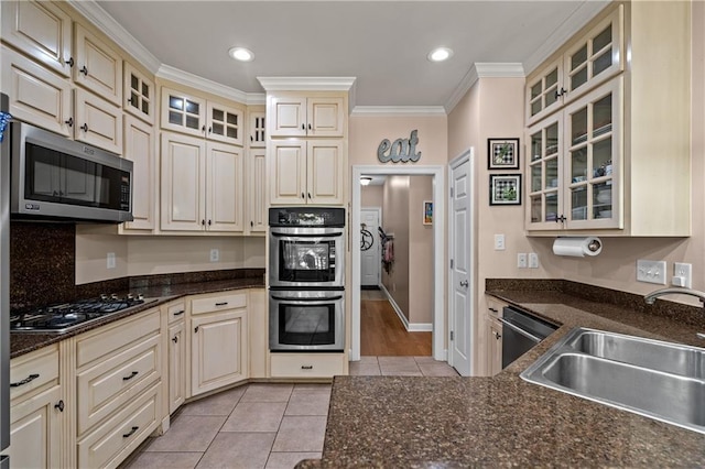 9791 Aspen Cir, Daphne, AL 36527 - kitchen with appliances with stainless steel finishes, cream cabinets, light tile patterned floors, ornamental molding, and glass insert cabinets