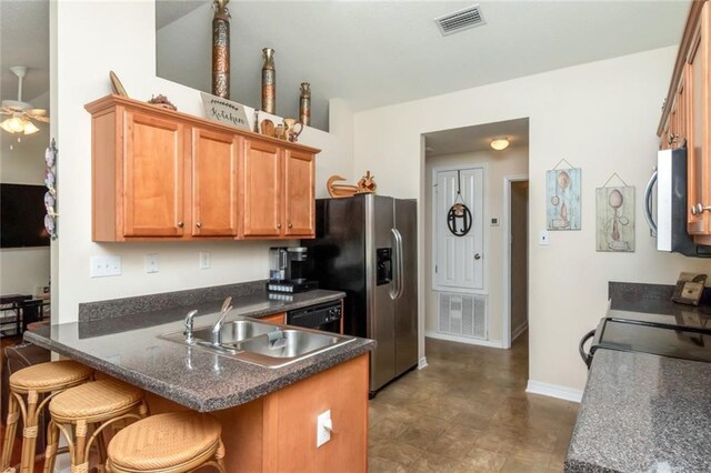 kitchen featuring dark tile patterned floors, sink, a kitchen breakfast bar, kitchen peninsula, and ceiling fan