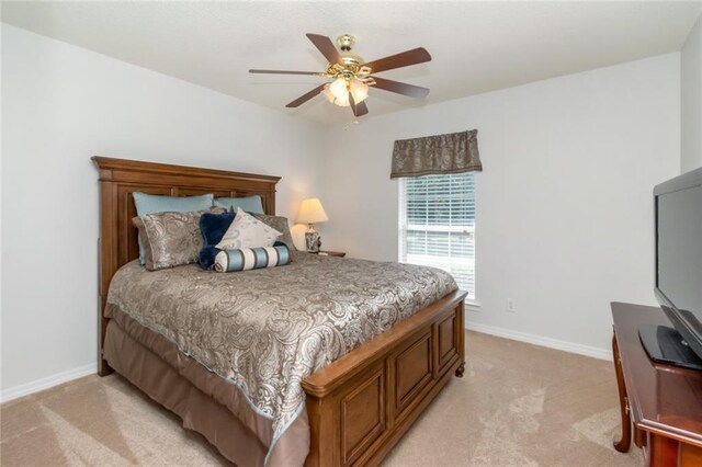 bedroom featuring ceiling fan and light carpet