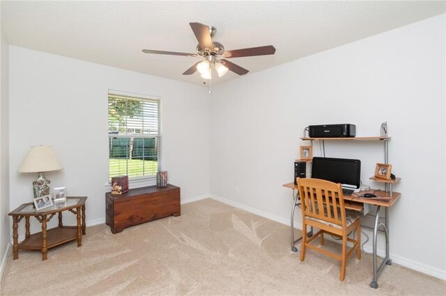 carpeted home office featuring ceiling fan