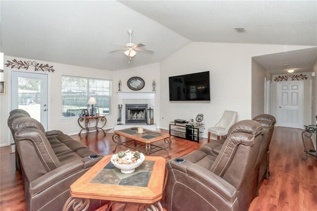 living room with a fireplace, ceiling fan, vaulted ceiling, and dark hardwood / wood-style floors