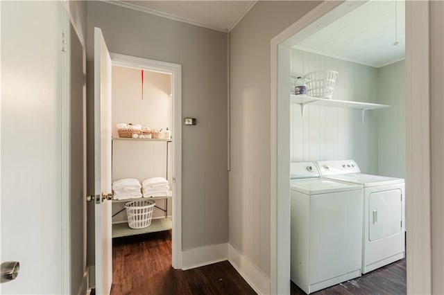 washroom featuring dark wood-type flooring, ornamental molding, and washer and clothes dryer