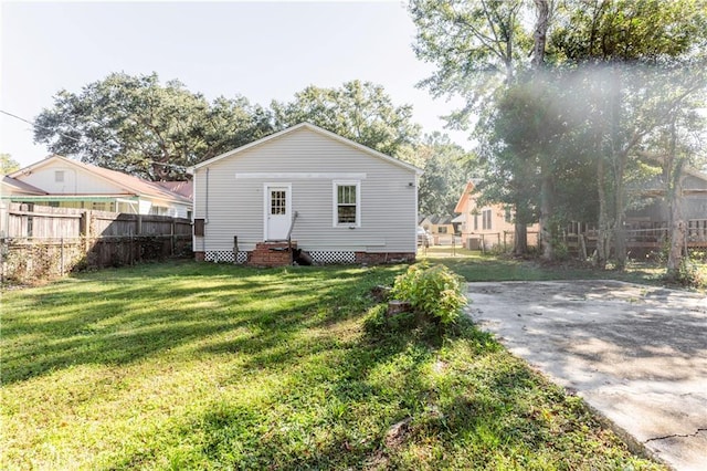 rear view of house featuring a lawn