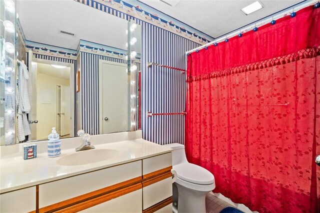 bathroom featuring tile patterned floors, vanity, and toilet