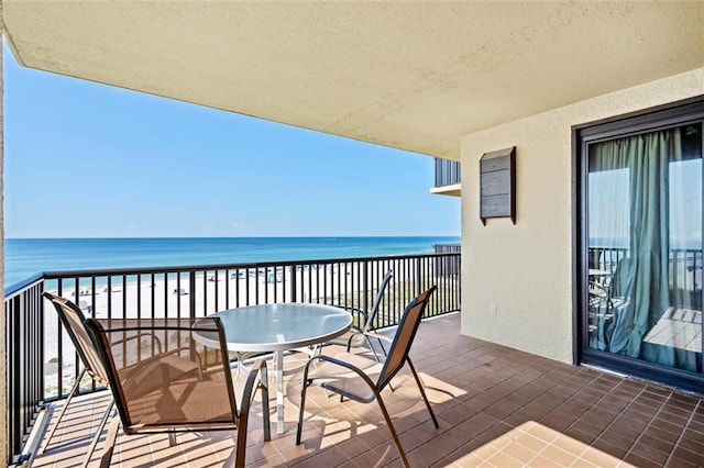 balcony featuring a beach view and a water view