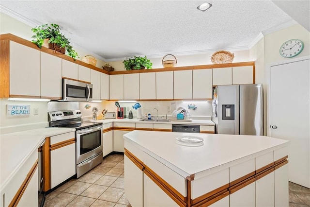 kitchen with sink, appliances with stainless steel finishes, light tile patterned floors, and ornamental molding