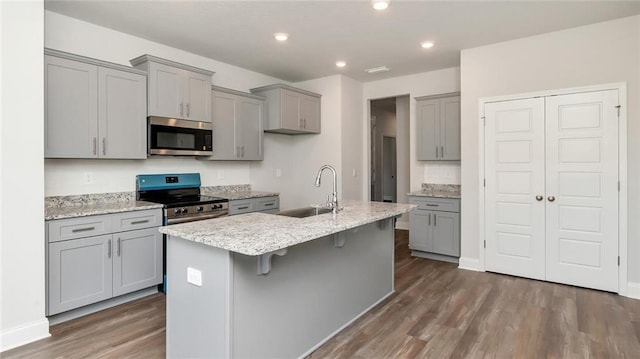 9836 Nadine Ln S, Mobile, AL 36695 - kitchen with stainless steel appliances, gray cabinetry, wood finished floors, a center island with sink, and recessed lighting