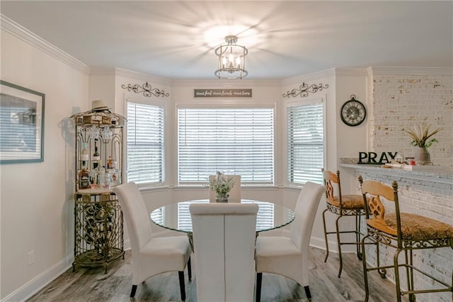 dining room featuring ornamental molding, a notable chandelier, and light wood-type flooring