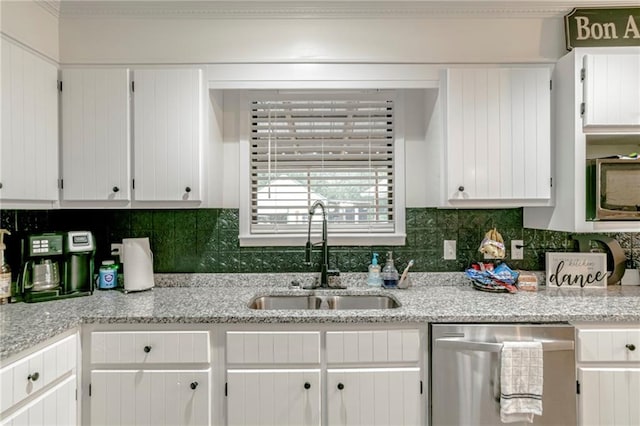 kitchen with white cabinets, stainless steel appliances, sink, and decorative backsplash