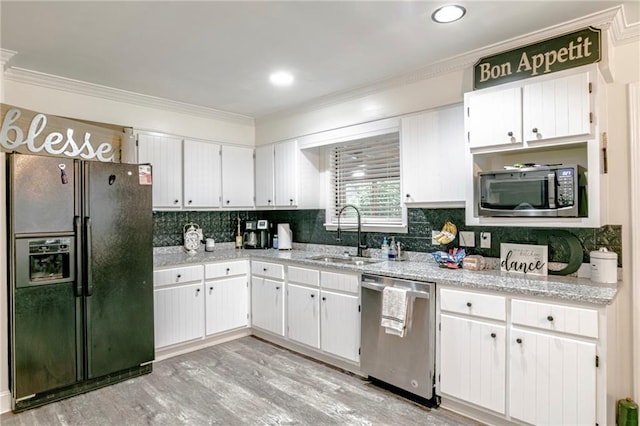 kitchen featuring white cabinets, crown molding, light hardwood / wood-style flooring, appliances with stainless steel finishes, and sink