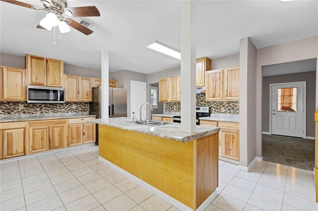 703 Townsend Cir, Chickasaw, AL 36611 - kitchen with stainless steel appliances, a sink, light brown cabinets, backsplash, and an island with sink