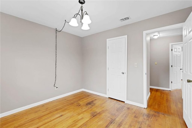 703 Townsend Cir, Chickasaw, AL 36611 - spare room featuring a chandelier, baseboards, and light wood-style floors
