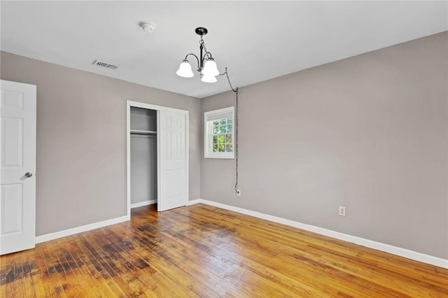703 Townsend Cir, Chickasaw, AL 36611 - unfurnished bedroom with a chandelier, baseboards, a closet, and wood finished floors