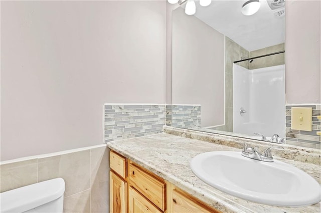 703 Townsend Cir, Chickasaw, AL 36611 - full bathroom with vanity, toilet, a shower, tile walls, and a wainscoted wall