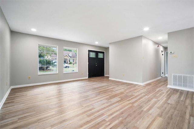 unfurnished living room with visible vents, baseboards, and light wood-style floors