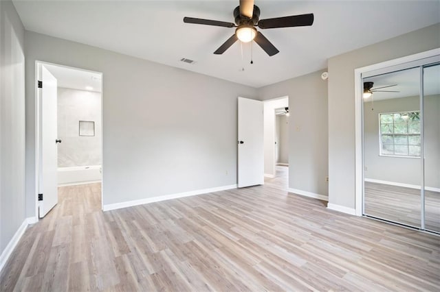 unfurnished bedroom featuring visible vents, baseboards, light wood-style flooring, a closet, and ensuite bath