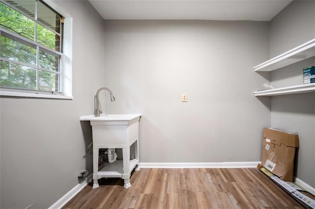 laundry area featuring baseboards and wood finished floors